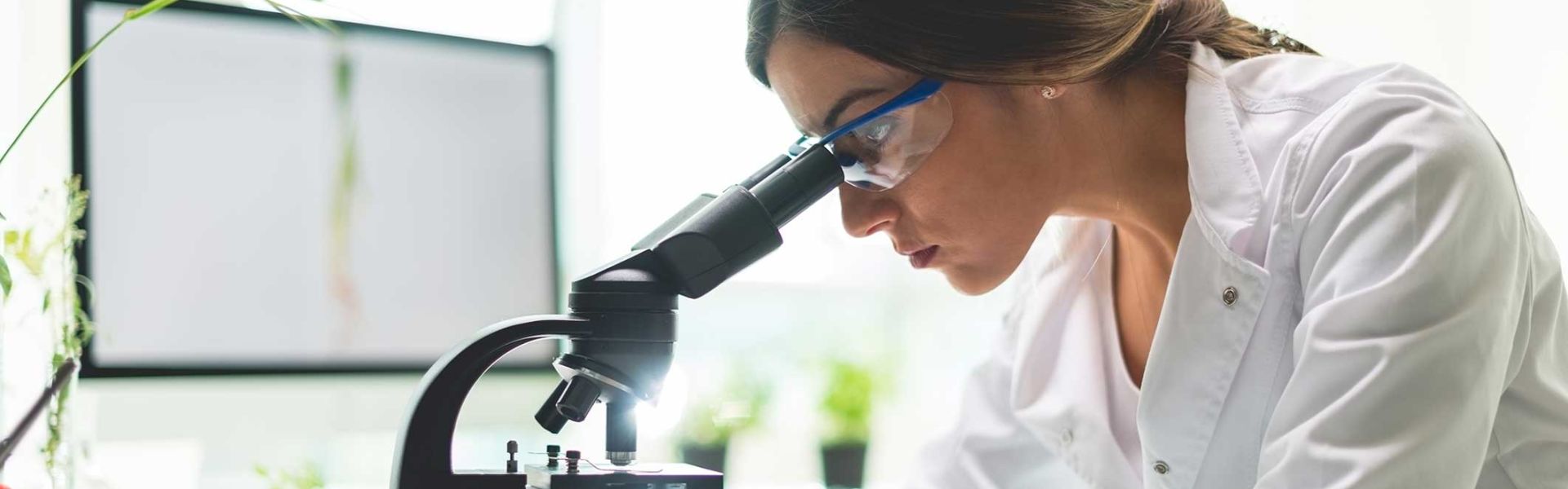 Une femme regardant dasn un microscope